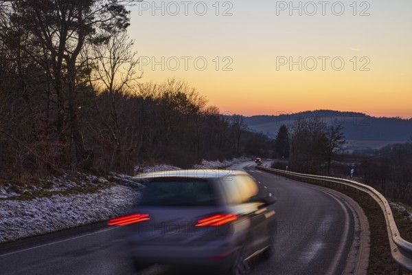 Country road, crash barrier, delineator, car, vehicle, brake light, reflector, motion blur, light traces, sunset, sunset, cloudless, hilly landscape, trees, federal road B421, Dreis-Brück, Eifel, Vulkaneifel district, Rhineland-Palatinate, Germany