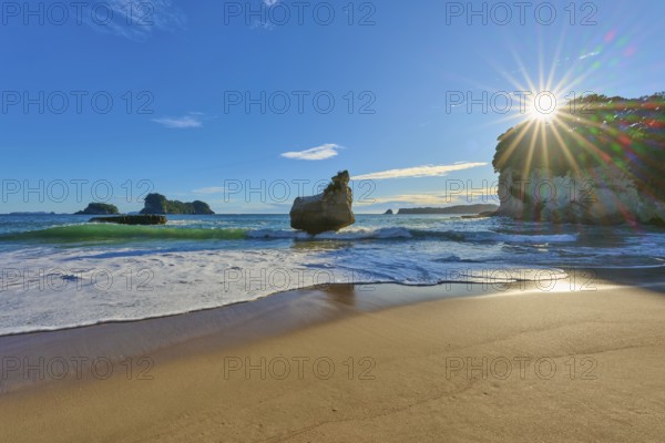Sunbeams breaking over a rocky beach, Cathedral Cove, Coromandel, Canterbury, North Island, New Zealand