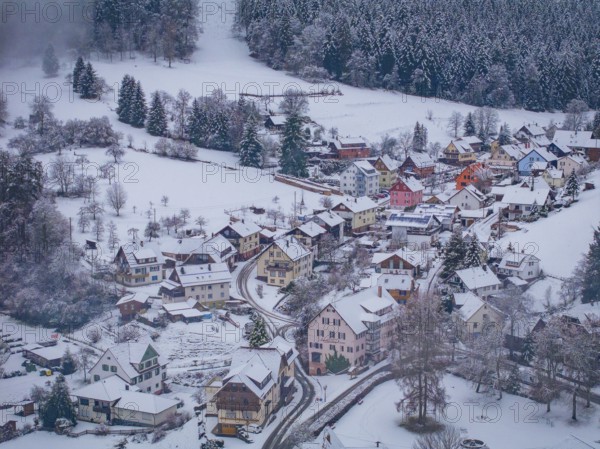 Snow-covered settlement with colourful houses on the edge of the forest, Enzklösterle, Calw district, Black Forest, Germany