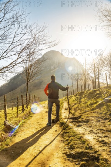 A man climbing Mount Ernio or Hernio in Gipuzkoa at sunset, Basque Country