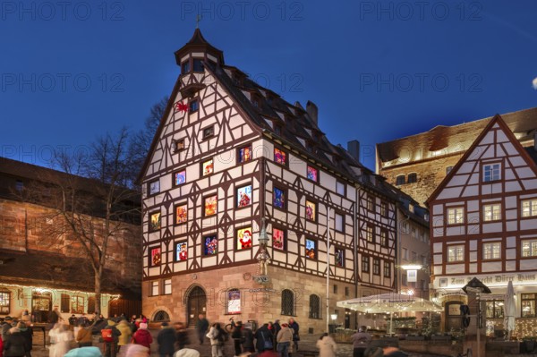 Historic Pilkatushaus with an Advent calendar on 18 December 2024 at dusk, behind the Imperial Castle, Tiergärtnertorplatz, Nuremberg, Middle Franconia, Bavaria, Germany