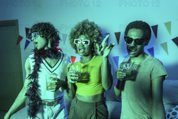 Multi-ethnic young students dancing and drinking alcohol during night party at home