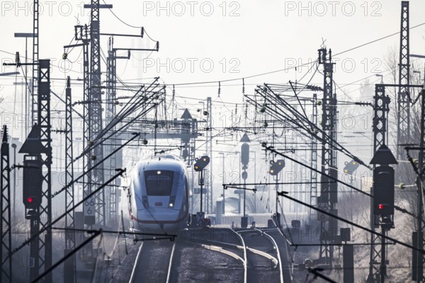 Deutsche Bahn AG tracks with ICE train against the light. Overhead line, signals and infrastructure. Railway tracks at the Geislinger Steige, Alb ascent to the Swabian Alb. Amstetten, Baden-Württemberg, Germany