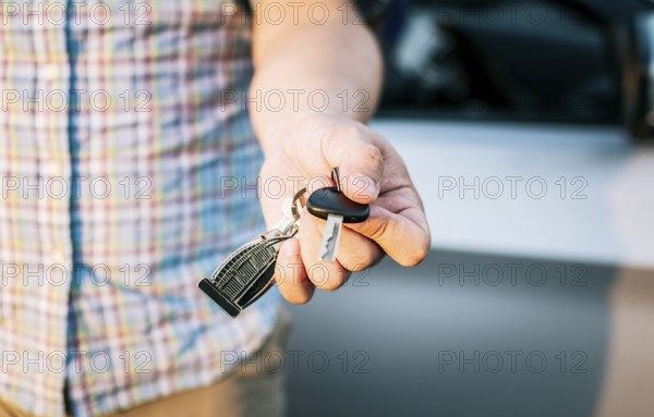 Driver's hands showing the car keys, Close-up of male driver hands showing the keys, Vehicle rental concept. Close-up of people holding car keys