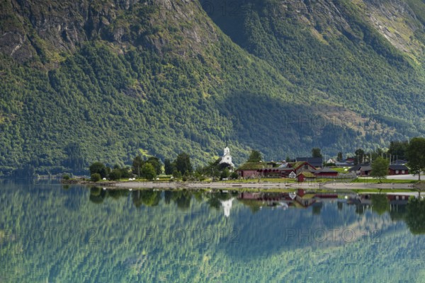 Reflection in lake Oppstrynsvatnet, white stave church, Oppstryn, Stryn, Norwege