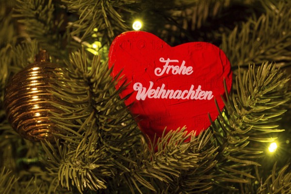 Christmas greetings: Heart with the inscription FROHE WEIHNACHTEN on a Christmas tree