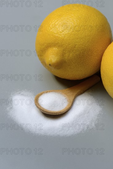 Citric acid in wooden spoon and lemon