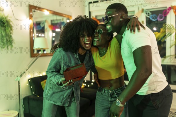 African young woman hugs her friends gratefully for a birthday gift at home