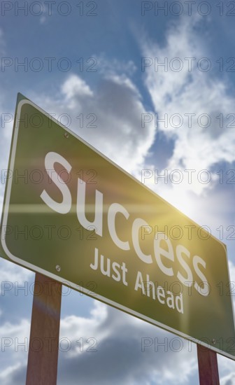 Success just ahead green road sign against a blue sky and clouds