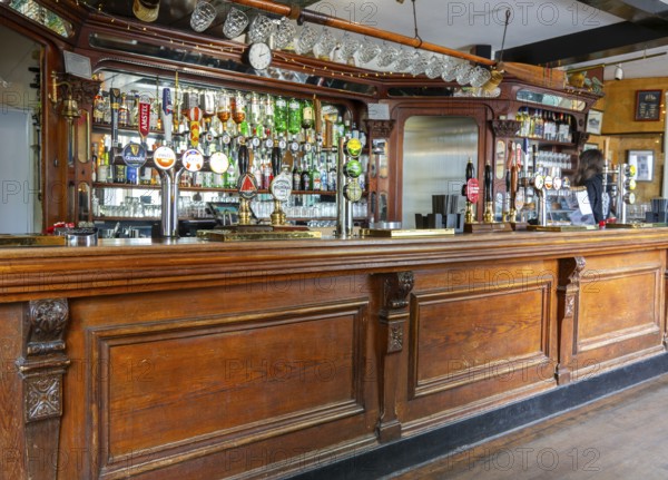 Traditional wooden bar counter with beer pumps inside Nova Scotia Hotel public house bar, Bristol, England, UK