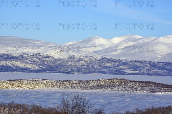 Snow-covered mountains and a frozen lake in a cold winter landscape, Abisko, Abisko National Park, Torneträsk, Lapland, Sweden