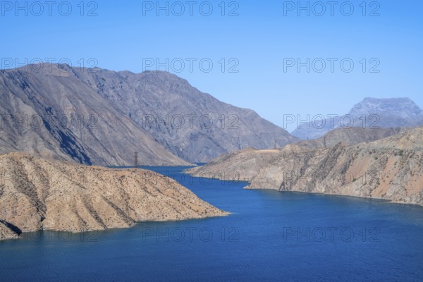 Blue Toktogul reservoir between dry mountain landscape, Jalalabad region, Kyrgyzstan