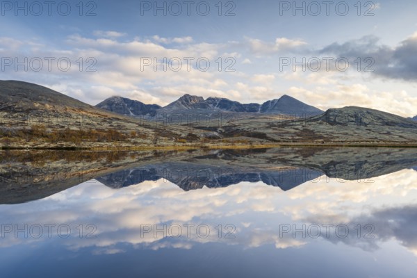 Reflection of the autumn landscape in Rondane National Park, mountains Høgronden, Midtronden and Digerronden Dørålen, Dørålseter, Norway