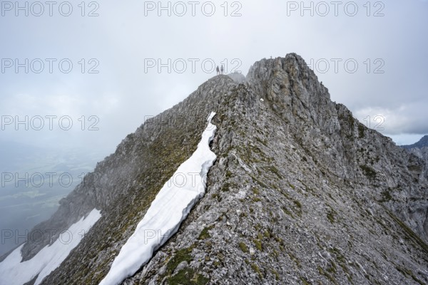 Two mountaineers on the rocky ridge, ascent to the Ackerlspitze, clouds moving around the mountains, Wilder Kaiser, Kaiser Mountains, Tyrol, Austria