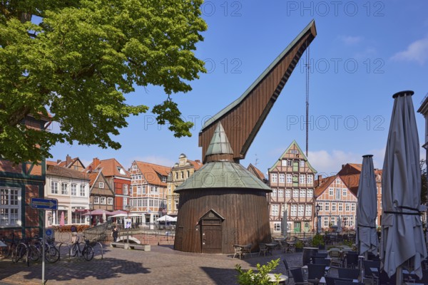 Old crane with outdoor area of a restaurant and historic half-timbered houses in the Hanseatic harbour in the old town of Stade, Hanseatic city, district of Stade, Lower Saxony, Germany