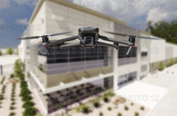 Unmanned aircraft system quadcopter drone UAV in the air near corporate industrial building