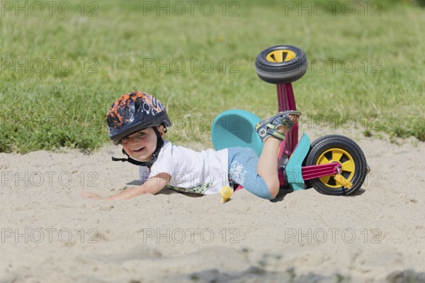 A boy in a helmet fell on his bicycle. Pobierowo, Poland