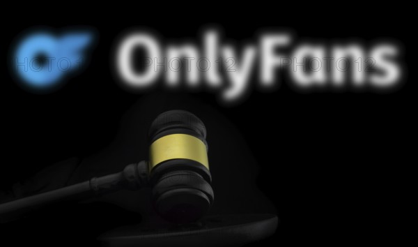 Court gavel in front of the OnlyFans logo. OnlyFans is an internet content subscription service based in London.