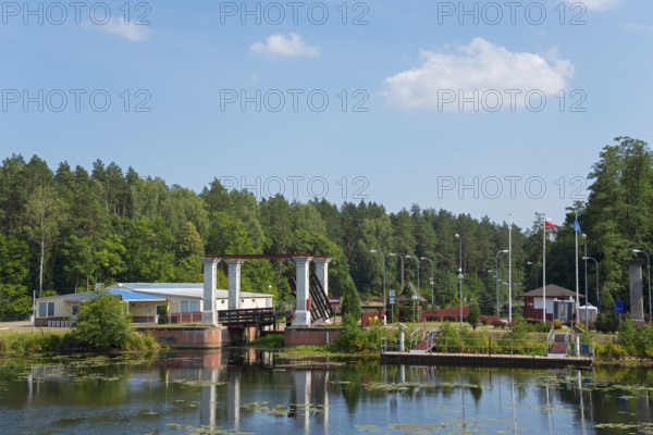 Lock with bridge and neighbouring building in forest landscape in sunshine, Sluza Kurzyniec, Sluza, lock, border between Belarus on the left and Poland on the right, Kanal Augustowski, Augustow Canal, Rudawka, Plaska, Plaska, Powiat Augustowski, Podlaskie, Podlaskie, Poland