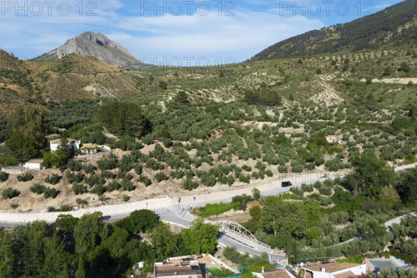 Green hills and a village on a winding road, surrounded by lush natural scenery, near Bedmar y Garcíez, Bedmar y Garciez, Sierra Mágina Natural Park, Jaén province, Jaen, Andalusia, Spain