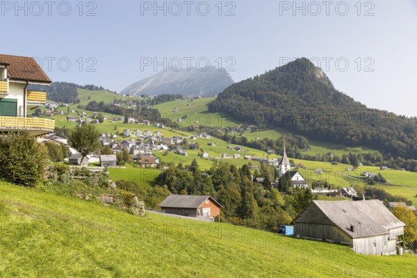View of Amden with church and Chapf, in the background the Churfirsten mountain range with the Leistchamm, St. Gallen, Switzerland