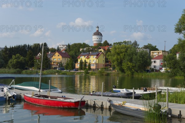 Red boat on the pier with a view of colourful houses and a water tower, summer atmosphere, Elk, Elk, Lyck, Jezioro Elckie, Warmia-Masuria, Poland