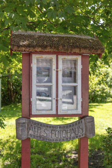 Small, wooden building with windows and an old sign in the countryside, Rügen, Hiddensee