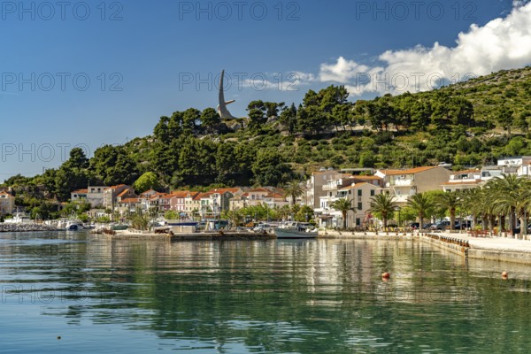 The Riva waterfront promenade and the seagull wing monument in Podgora, Croatia