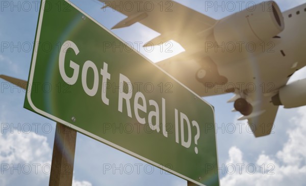Got real ID? green road sign with low flying airplane just above with landing gear down