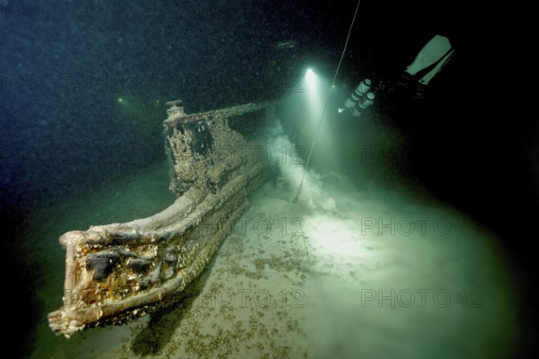 Underwater image of a diver approaching a shipwreck with a light source, dive site wreck of the Jura, Lake Constance, Bottighofen, Switzerland, Münsterlingen, Germany