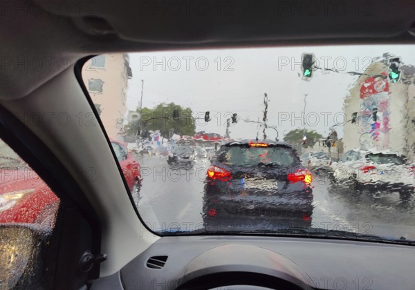 Daytime view from a car in heavy rain with an unclear view of the traffic at a traffic light, Witten, Ruhr Area, Germany