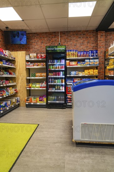 A supermarket interior with modern shelving and refrigeration units in front of a brick wall, Tante M, self-service shop, Enzklösterle, Calw district, Black Forest, Germany