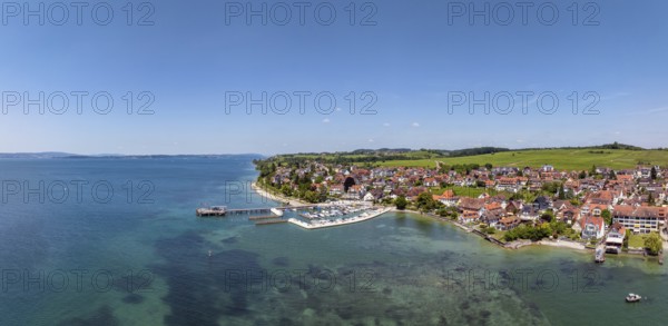 Luftbild, Panorama von der Bodenseegemeinde Hagnau, Winzerdorf und beliebter Ferienort am Bodensee, dahinter Rebhänge, auf denen hauptsächlich die Weinsorten Müller Thurgau und Blauer Burgunder angebaut werden. Am Seeufer der am 23.Mai 2025 eingeweihte, neue Westhafen, Yachthafen mit der Schiffanlegestelle, Bodenseekreis, Baden-Württemberg, Deutschland