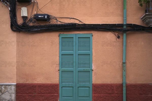 Power lines run outside the house wall, ochre-coloured, Alaró, Calvià, Majorca, Balearic Islands, Balearic Islands, Spain