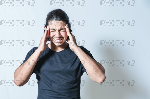 Headache and migraine concept. Suffering man with migraine massaging head isolated