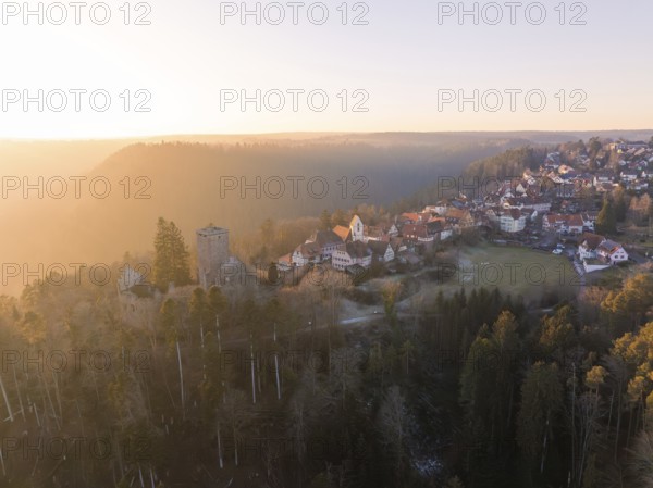 View of a village with a ruin in a hilly forest landscape at sunset, Zavelstein, district of Calw, Black Forest, Germany