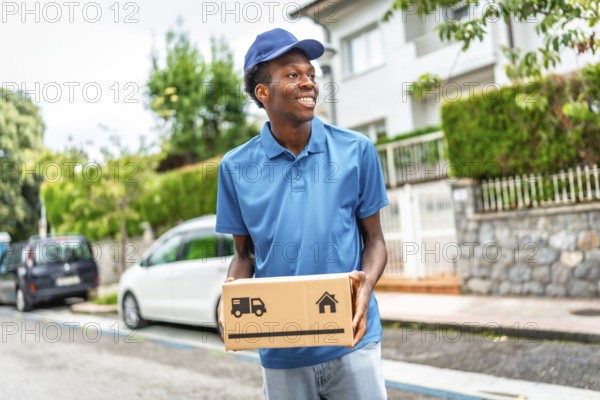 African courier with blue uniform delivering parcels in a residential street