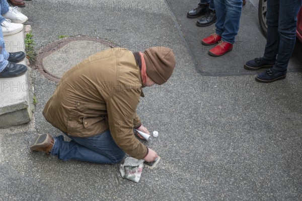 Pupil polishes and cleans a stumbling stone to commemorate the Night of Broken Glass on 9 November 1938, stumbling stone tour in Schnaittach, Middle Franconia, Bavaria, Germany