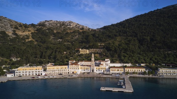 Drone shot, coastline with harbour and historic buildings surrounded by mountains, Holy Week, Bay of Panormitis, Panormitis Monastery, Symi, Dodecanese, Greek Islands, Greece