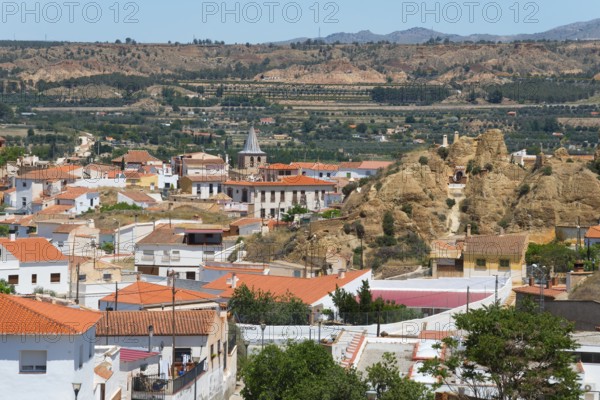 Panoramic view of a village with red roofs and mountains in the background under a clear sky, cave dwellings, cave district, Troglodytos, Barrio de Cuevas, Guadix, Granada province, Andalusia, Spain