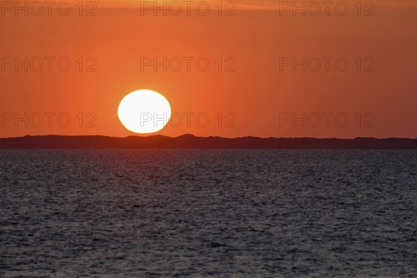Sunset over the North Sea, on the horizon the contours of the island of Juist, Norddeich, Lower Saxony, Germany
