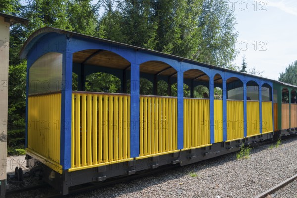 Blue and yellow wagon on tracks in a quiet forest environment, Wigry narrow-gauge railway, Plociczno-Tartak, Suwalki, Podlaskie, Poland