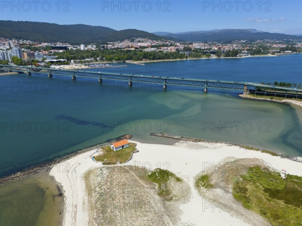 View of a city with hills connected by a bridge over a river that flows into the ocean, with a light-coloured sandy beach and clear water, aerial view, Ponte Eiffel, bridge by Gustave Eiffel, Lima River, Viana do Castelo, Portugal