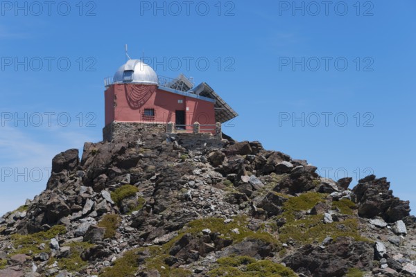 Close-up of a red observatory on a rocky hill under a blue sky, Obversatorium, Mohon del Trigo Observatorio, Observatorio del Mojón del Trigo, Güéjar Sierra, Güejar, Sierra Nevada, Andalusia, Spain