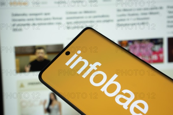 Dhaka, Bangladesh - 17 March 2025: The logo of the newspaper infobae is displayed on a smartphone screen, and the website infobae is visible on a computer screen in the background
