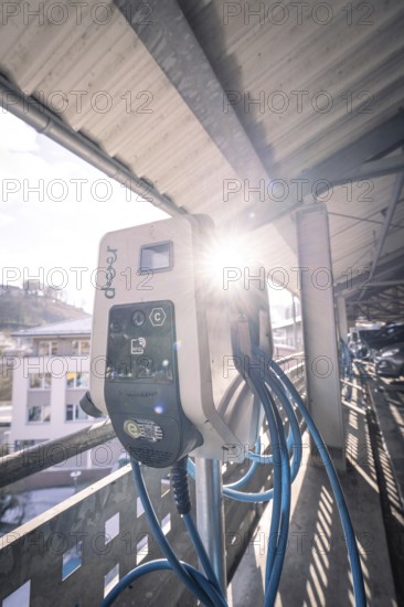 Electric charging station illuminated by sunlight, with blue cables, Kaufland Calw multi-storey car park, Calw district, Black Forest, Germany
