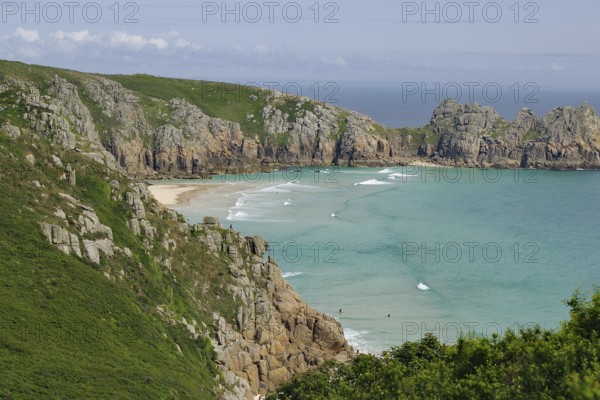Felsen und Strand an einer Küste mit klarem Wasser und blauen Himmel, Porthcurno, St Levan, Cornwall, Großbritannien