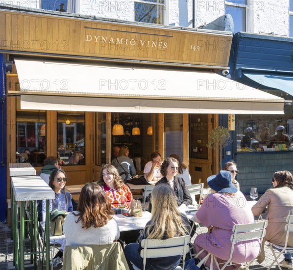 People sitting outside Dynamic Vines wine shop, East Dulwich, London, England, UK