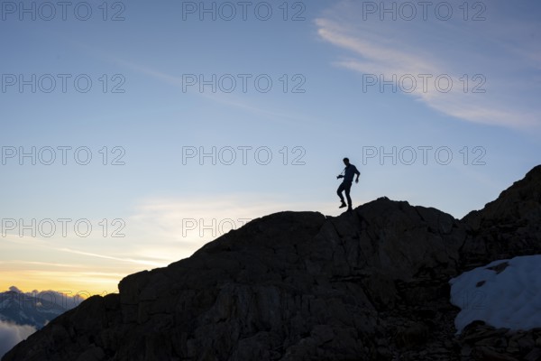 Silhouette of a photographer in front of a blue sky, mountain landscape at sunset, Chamonix, Haute-Savoie, France