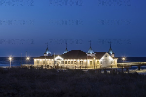 Restaurant on Ahlbeck Pier, Seebrücke Ahlbeck illuminated at dusk in the Baltic Sea on Usedom island, Mecklenburg-Vorpommern, oldest pier in Germany